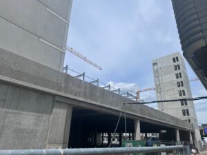 Betonparkhaus im Rohbau mit Treppenturm und Baukränen, Parkhaus Motorworld München