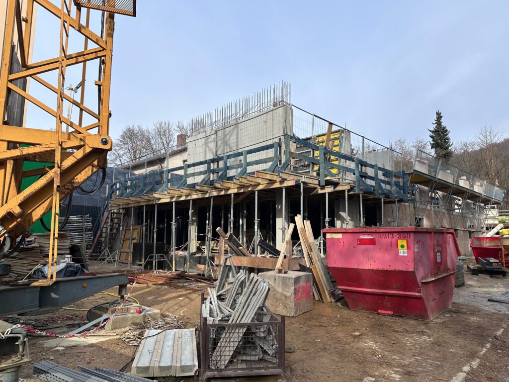 Rohbau der Wohnanlage in Amberg mit Deckenschalung, im Vordergrund Kran und Container